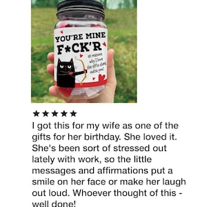 Puede incluir: Un frasco de vidrio transparente con tapa negra que contiene notas de papel. La etiqueta muestra un gato negro con arco y flecha, corazones rojos y el texto: YOU'RE MINE F*CK'R 48 reasons why I love the effin sh*t outta you! El frasco contiene papel rojo.