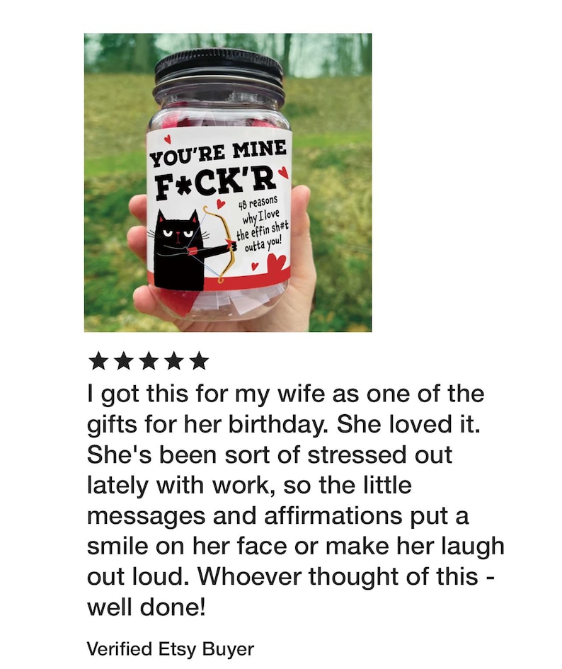 Puede incluir: Un frasco de vidrio transparente con tapa negra que contiene notas de papel. La etiqueta muestra un gato negro con arco y flecha, corazones rojos y el texto: YOU'RE MINE F*CK'R 48 reasons why I love the effin sh*t outta you! El frasco contiene papel rojo.