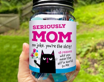 May include: A clear glass jar with a black lid, filled with small notes. The jar has a label with the text "SERIOUSLY MOM" in pink, and a black cat illustration. The text below reads "no joke. you're the sh*t!" and "48 reasons why you mean the eff'in World to Me."