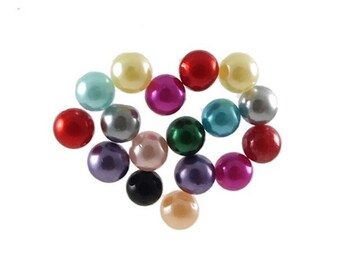 May include: A collection of seventeen spherical beads with a smooth, glossy finish in a variety of colours including red, blue, green, yellow, purple, pink, black, silver, and cream, arranged in a loose cluster against a plain white background.