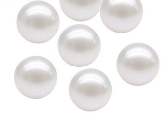 May include: A collection of six smooth, spherical white beads with a lustrous, pearlescent finish. Each bead is round and uniform in shape, reflecting light across its polished surface. The beads are arranged in a loose cluster against a plain background.