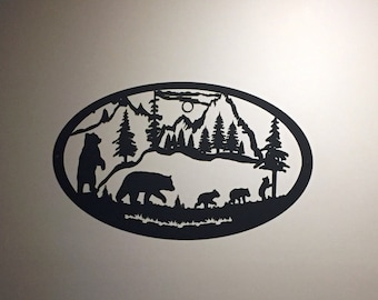 May include: Black metal wall art depicting a family of bears walking through a mountain landscape with a full moon in the sky.