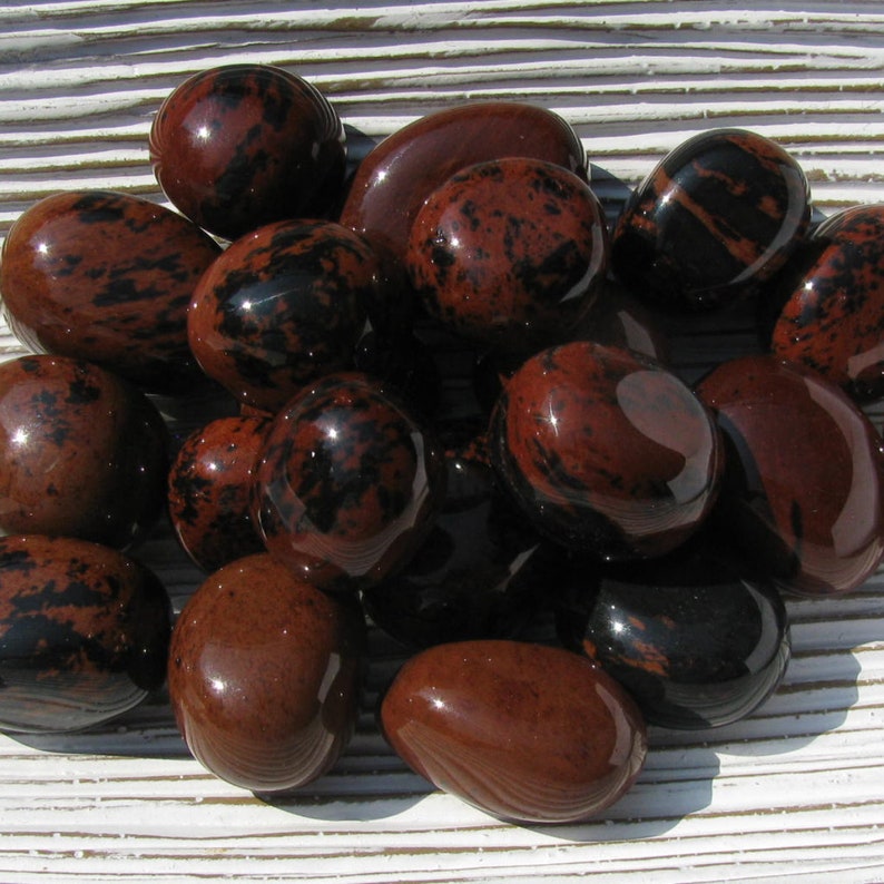 Peut inclure: Une collection de pierres de jaspe rouge et noir roul&eacute;es. Les pierres sont lisses et polies, avec une vari&eacute;t&eacute; de motifs et de marques.