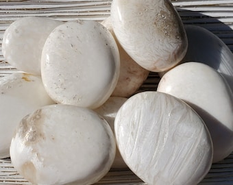 May include: A collection of smooth, white, oval-shaped stones with a subtle, marbled pattern. The stones have a polished, glossy finish.