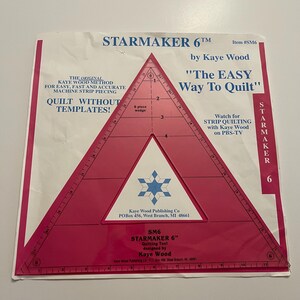 May include: A Starmaker 6 quilting tool by Kaye Wood. The triangular tool is red and white, with measurements along the edges. Text includes "The Easy Way to Quilt" and "Quilt Without Templates!"