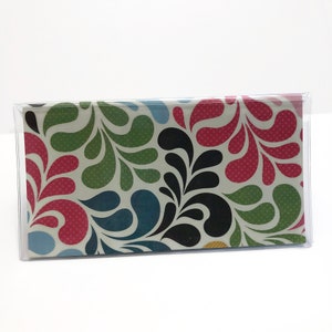 May include: A clear plastic case with a colorful patterned design. The pattern features red, green, blue, and black teardrop shapes with white polka dots.