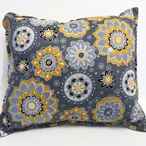May include: A gray and yellow patterned throw pillow with a floral design. The pillow is made of a soft, comfortable fabric and has a square shape.