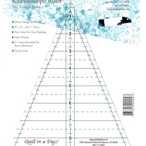 May include: A clear acrylic Kaleidoscope Ruler, also known as The Triangle Ruler, with black and green markings. It features 1/4", 1/2", and 1" lines, a center line, and is laser precise. The ruler is designed for quilting and includes the text "Quilt in a Day".