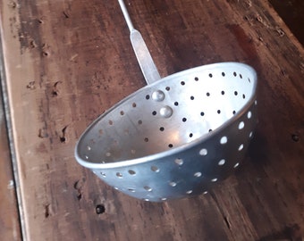 Vintage metal strainer ladle with hanging hook.