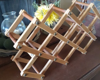 Vintage wooden wine rack expandable, light blonde wood tone with brass grommets farmhouse, country, French décor, kitchen, bar area.