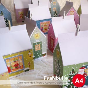 Könnte beinhalten: Ein druckbarer Adventskalender mit einer Reihe kleiner Häuser mit festlichen Details, darunter Schnee, Lichter und Weihnachtsbäume. Die Häuser sind zum Ausschneiden und Zusammenbauen gedacht. Der Text "FraNbulle Calendrier de l'Avent / Advent Calendar A4" ist unten im Bild gedruckt.