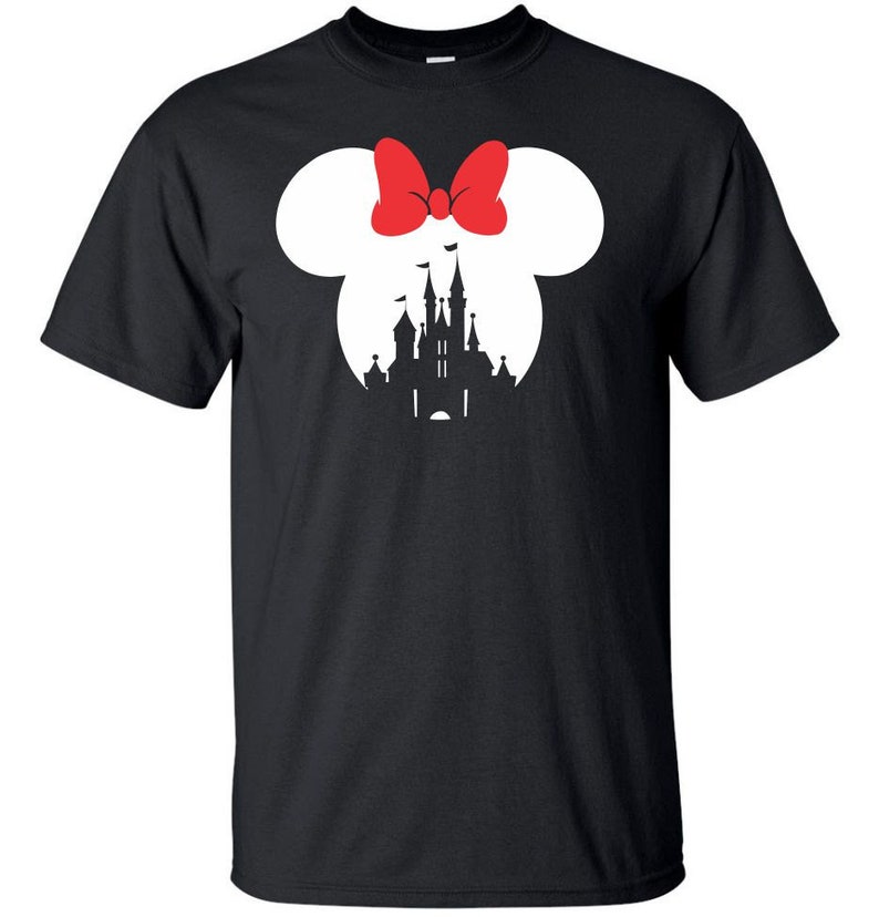 Op de afbeelding: Zwart T-shirt met een wit silhouet van Assepoester's kasteel en een paar Mickey Mouse oren met een rode strik.