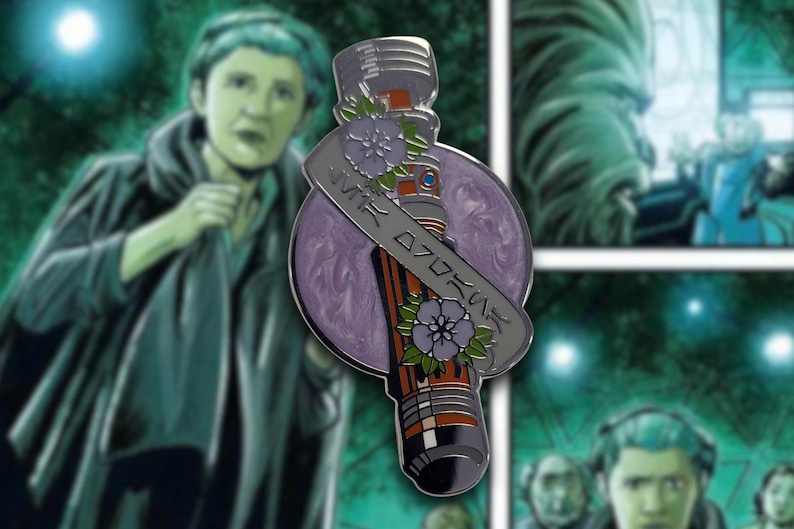 May include: A detailed pin featuring a lightsaber design with a purple and orange color scheme. The pin includes a banner with Japanese text and floral accents. The background is a comic book style illustration with a green and blue color palette.