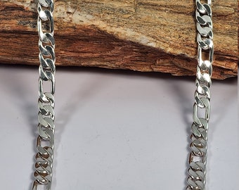 May include: A silver curb chain necklace with a classic design. The chain is made of polished metal and has a smooth, shiny finish.