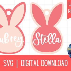 May include: Two pink bunny-shaped tags with the names Aubrey and Stella written in white. The tags are laser cut and ready to be used.