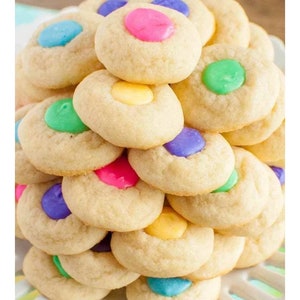 May include: A stack of sugar cookies with pastel-colored candy melts in the center. The cookies are arranged in a pyramid shape.