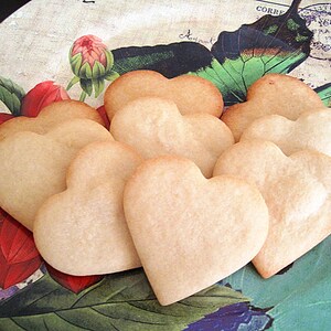 May include: A plate of heart-shaped sugar cookies, decorated with a vintage floral and butterfly design.