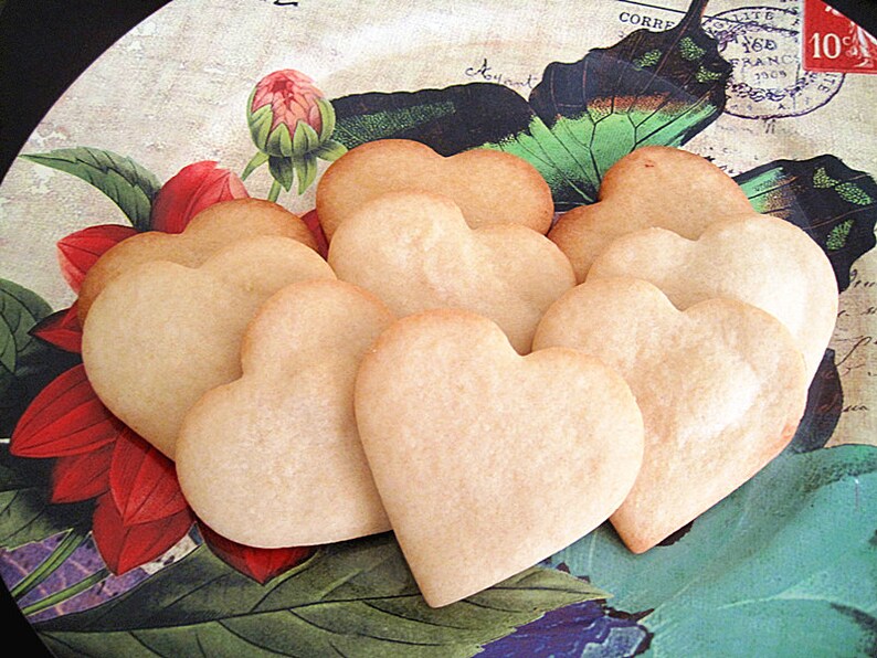 May include: A plate of heart-shaped sugar cookies, decorated with a vintage floral and butterfly design.