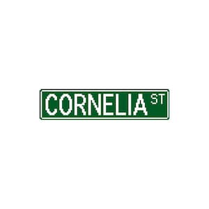 May include: A green street sign with white text reading "CORNELIA ST". The sign is rectangular with a white border. The background is white.