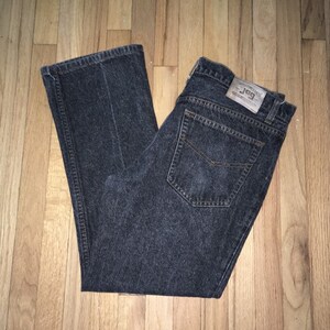 Könnte beinhalten: Eine dunkelgraue Jeanshose mit einem braunen Leder-Patch, auf dem "J.G.P. Authentic Denim" steht.