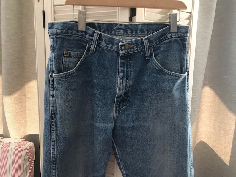 May include: A pair of blue denim jeans with a classic five-pocket style. The jeans have a straight leg and a button fly.