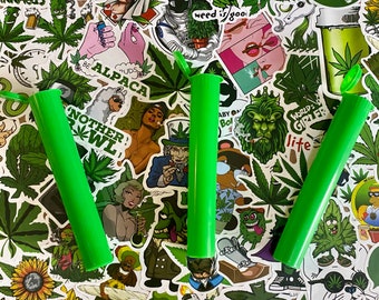 May include: Three bright green, cylindrical tubes with flip-top lids are displayed against a backdrop of cannabis-themed stickers. The stickers feature various illustrations, including cannabis leaves, cartoon characters, and text like "weed is good" and "Nother Bowl".
