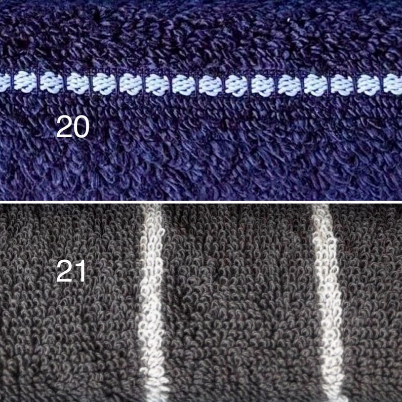 Op de afbeelding: Een gesplitste afbeelding met twee texturen van badstof. Het bovenste gedeelte is donkerblauw met een horizontale witte geborduurde lijn met het label 20. Het onderste gedeelte is donkergrijs met verticale witte strepen met het label 21.