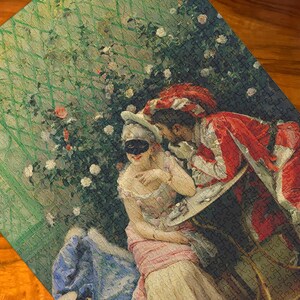 May include: A completed jigsaw puzzle featuring a romantic scene with figures in period costumes. The artwork depicts a masked woman and a man in red and white attire, set against a backdrop of a garden with roses.