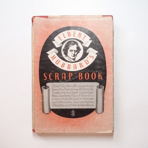 以下が含まれることがあります： 「エルバート・ハバードのスクラップブック」というタイトルの赤と黒の表紙の書籍。表紙にはエルバート・ハバードの肖像画と彼の著作からの引用が掲載されている。