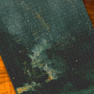 Pode incluir: Um quebra-cabeça completo com um design abstrato em verde escuro e dourado. O quebra-cabeça está em uma superfície de madeira com um tom quente de marrom-alaranjado. As peças do quebra-cabeça estão interligadas, criando uma imagem coesa.