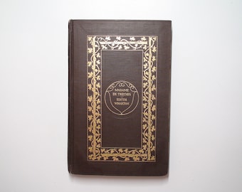 May include: A brown hardcover book with a gold-colored decorative border and the title "Madame de Treymes" by Edith Wharton.