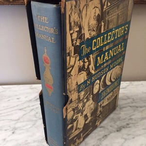 May include: An antique book titled "The Collector's Manual" by N. Hudson Moore. The book is in a blue cover with gold lettering and a decorative design. The book is housed in a worn, illustrated slipcase with the title and "336 Engravings".
