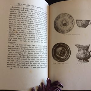 May include: An open book with illustrations of antique dishware, including a plate, cup, and pitcher. The text on the page describes Wedgwood's wares and their history. The book is open to a page with text and illustrations.