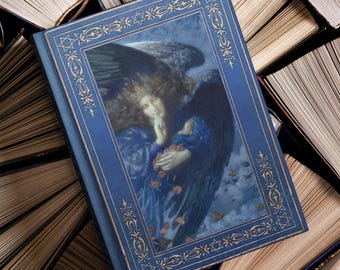 May include: A blue hardcover book with a gold-colored decorative border and an illustration of an angel with large wings. The book is surrounded by open books with aged, yellowed pages, creating a vintage aesthetic.