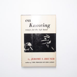 May include: A white book cover with black text that reads "on Knowing essays for the left hand by JEROME S. BRUNER author of THE PROCESS OF EDUCATION". The cover features a black and white photo of a hand reaching out.