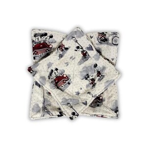 May include: A square fabric bowl cozy featuring a cream-colored background with a repeating pattern of Mickey and Minnie Mouse in a red car, the Eiffel Tower, and bicycles. The quilted material has a dotted texture and dark red accents.