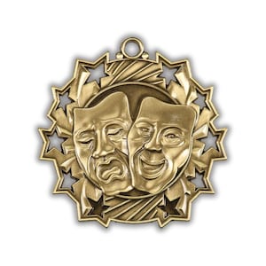May include: A gold-colored theater award or medal featuring the comedy and tragedy masks. The masks are set against a circular background, surrounded by a starburst design with cut-out stars. A small loop is at the top for hanging.