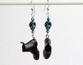 May include: A pair of dangle earrings featuring miniature black boots with iridescent blue skull charms.