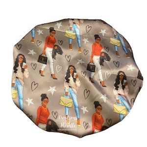 May include: A gray satin bonnet with a repeating pattern of women carrying purses and wearing red tops and blue jeans. The pattern also includes hearts and stars. The text "Creations By Shirelle" is printed on the bonnet.