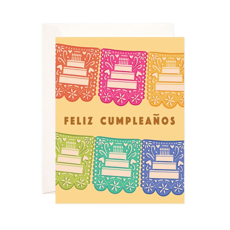 May include: A colorful birthday card with a festive design of paper banners featuring cake illustrations and the text "Feliz Cumplea&ntilde;os".