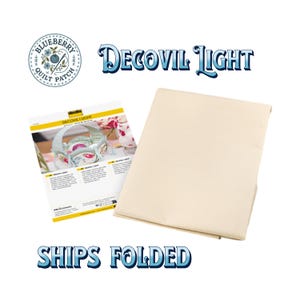May include: A folded sheet of beige Decovil Light interfacing fabric next to an informational product sheet featuring the text Decovil Light and Ships Folded. The product sheet displays a floral basket craft project and brand information.