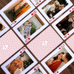 May include: Custom playing cards featuring personal photos. The cards have a white border and a red and white patterned back. The faces of the cards display various images, including couples and pets. The deck includes the text "R&A 07.12.26".