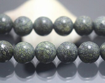 Peut inclure: Un collier de perles rondes tachetées de vert foncé et de noir. Les perles sont lisses et ont un aspect marbré.