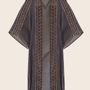 May include: A dark charcoal grey open-front kimono featuring wide sleeves and a prominent vertical zigzag pattern in a light tan colour along the front edges and sleeve cuffs. The garment includes a subtle geometric design at the back neckline.