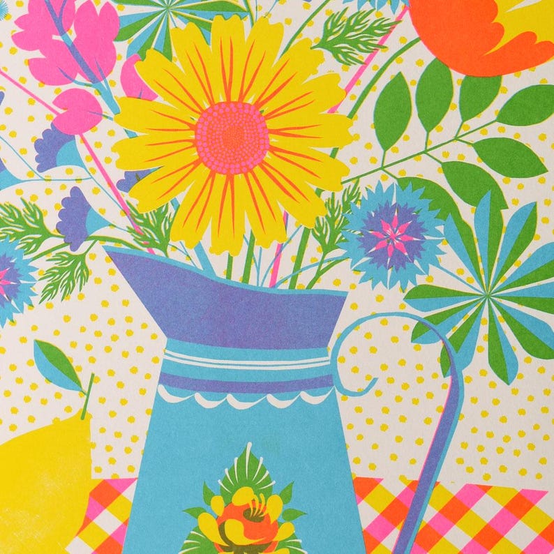 May include: A blue pitcher with white and blue stripes and a floral design on the bottom, filled with a bouquet of yellow, pink, and blue flowers. The flowers are on a white background with yellow polka dots.