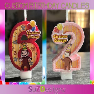 May include: Custom birthday candles shaped as the numbers 6 and 2. The number 6 is red with Curious George and balloons. The number 2 is pink with Curious George and balloons. The candles have the text "Custom Birthday Candles" at the top.