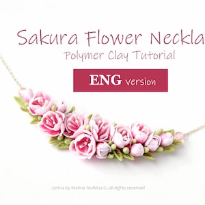 Puede incluir: Un collar de arcilla polimérica rosa con un grupo de delicadas flores de cerezo rosas y blancas. El collar está sobre un fondo blanco con el texto "Sakura Flower Necklace Polymer Clay Tutorial ENG version" encima.