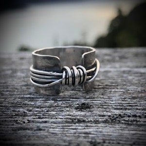 Hand made wide band sterling silver knot ring with open band.