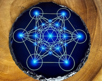 May include: A blue agate coaster with a white geometric design, resembling a flower of life pattern. The design is outlined in white and has glowing blue accents.