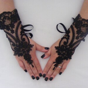 May include: A pair of black lace fingerless gloves with a ribbon tie at the wrist.